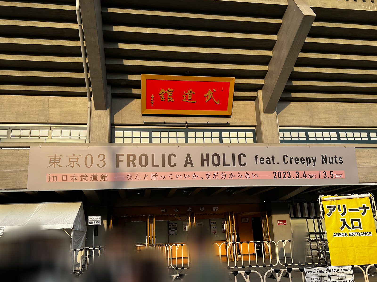 『東京03 FROLIC A HOLIC feat. Creepy Nuts in 日本武道館　なんと括っていいか、まだ分からない』の大看板が掲げられた日本武道館正面口。