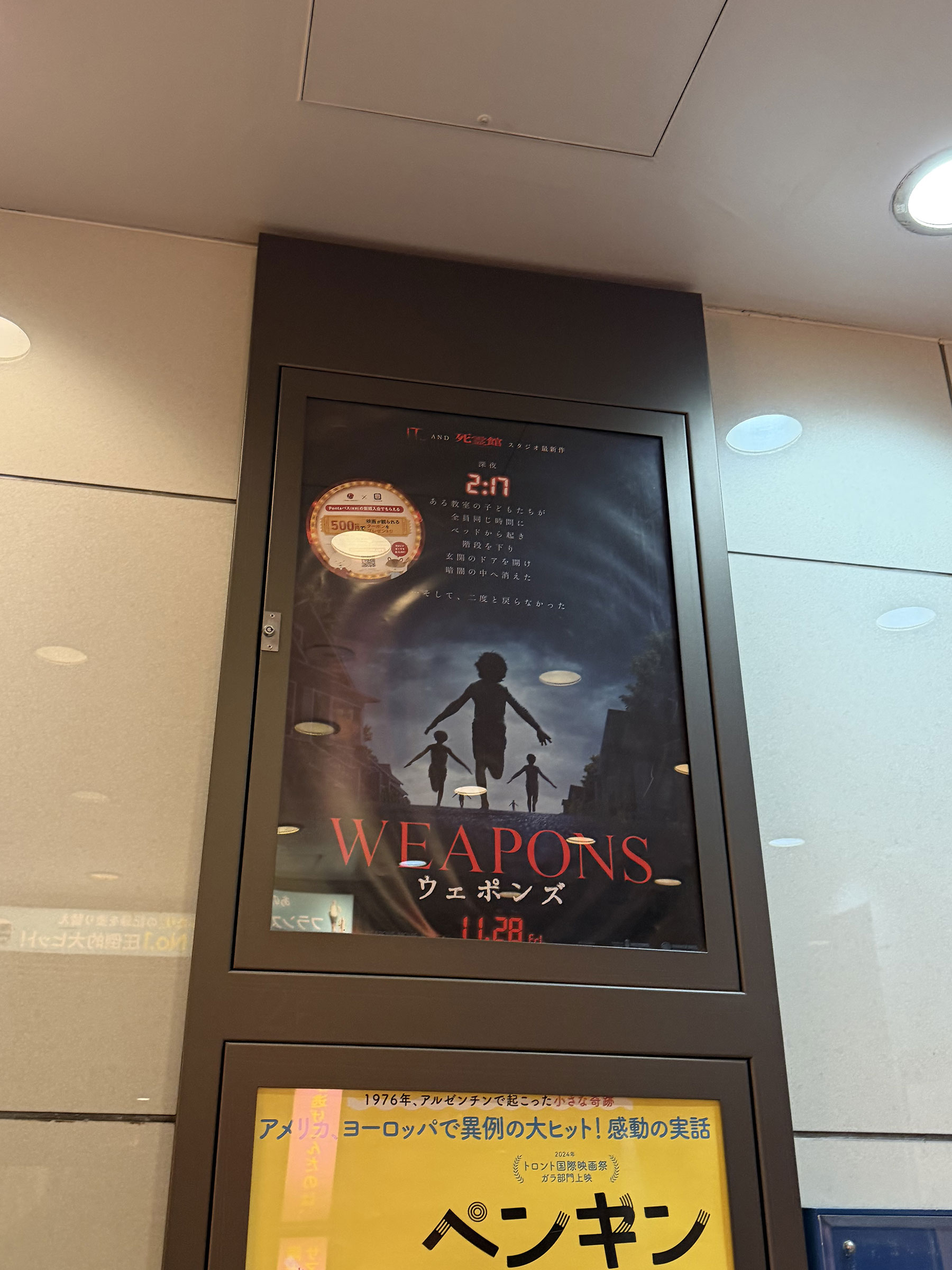 TOHOシネマズシャンテ、チケットカウンター向かいの壁面に掲示された『WEAPON/ウェポンズ』ポスター。 TOHOシネマズシャンテ、チケットカウンター向かいの壁面に掲示された『WEAPON/ウェポンズ』ポスター。