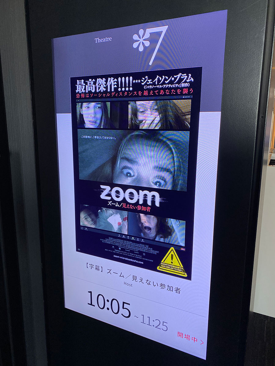 新宿ピカデリー、スクリーン７入口前のデジタルサイネージに表示された『ズーム／見えない参加者』キーヴィジュアル。
